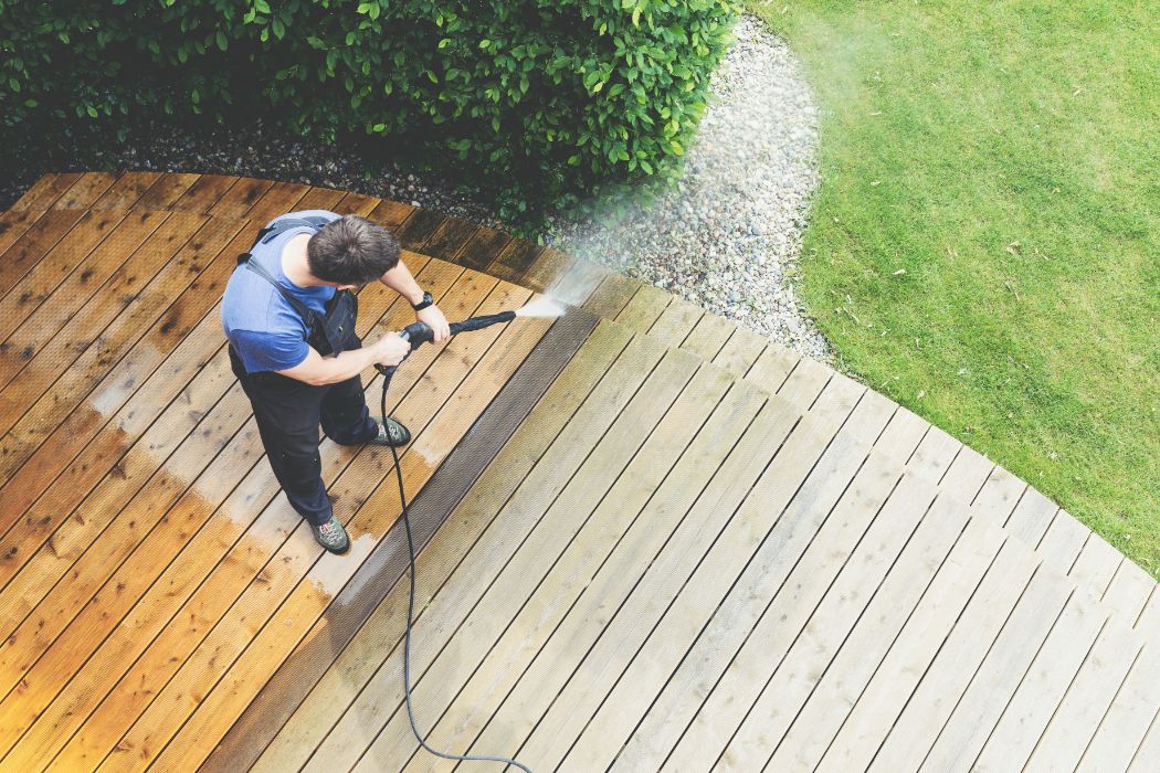 man cleaning terrace with a pressure washer - Rensfliser - Rensfliser Rensning af træterrasse. Alt du skal vide om træterrasserens og om du skal gøre det selv eller få det lavet professionelt
